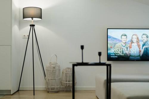 a living room with a flat screen tv on a wall at Ático Isabel, diseño y calidez junto a la Muralla Romana in Lugo