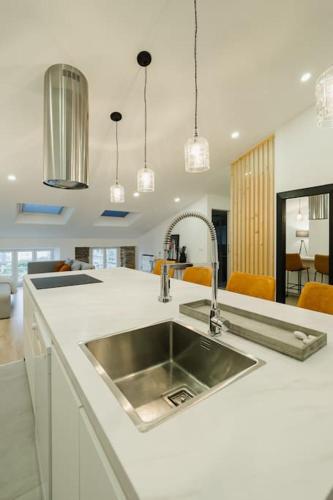a kitchen with a sink in a white counter top at Ático Isabel, diseño y calidez junto a la Muralla Romana in Lugo
