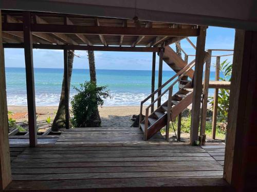a wooden staircase leading to a beach with the ocean at CABAÑA TELLO SURF in Nuquí