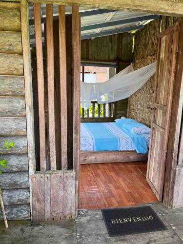 an open door to a bedroom with a bed at CABAÑA TELLO SURF in Nuquí