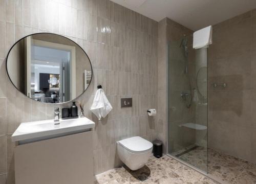 a bathroom with a toilet and a shower and a mirror at Aglaya 1 - Luxury 2BR Apartment in Belgrade