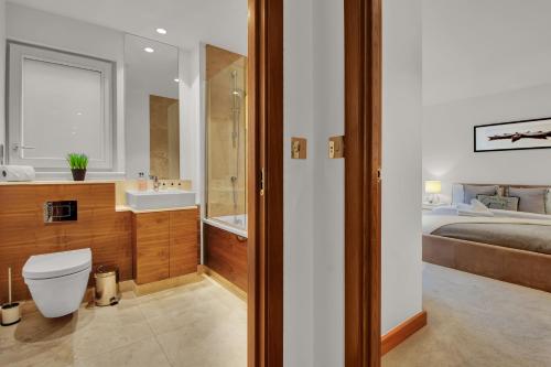 a bathroom with a toilet and a sink and a bed at Modern Apartments close to Colombia Road Flower Market in London