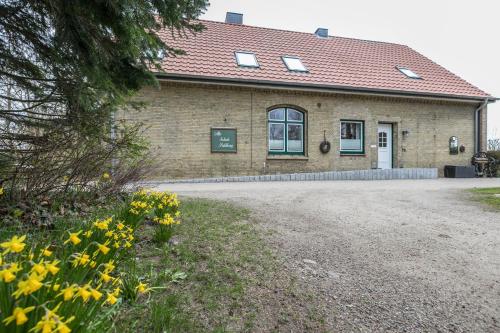 a brick building with yellow flowers in front of it at Alte Schule Pahlkrug in Linden