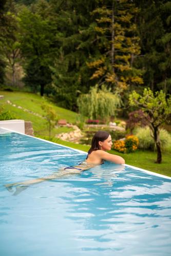 a woman sitting in a swimming pool at Rota Apartments in Rota d'Imagna