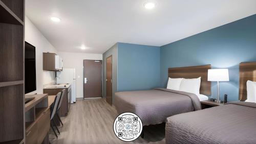 Habitación de hotel con 2 camas y TV en WoodSpring Suites Downers Grove - Chicago en Downers Grove