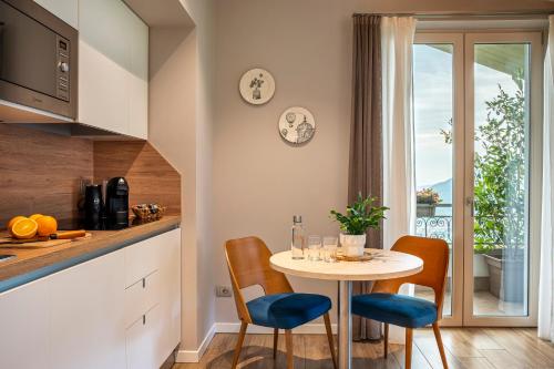 a kitchen with a small table and chairs and a kitchen with a window at Rota Apartments in Rota d'Imagna