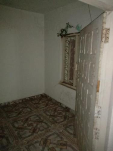 une chambre vide avec une porte et une fenêtre dans l'établissement Kailas 4, à Kollam