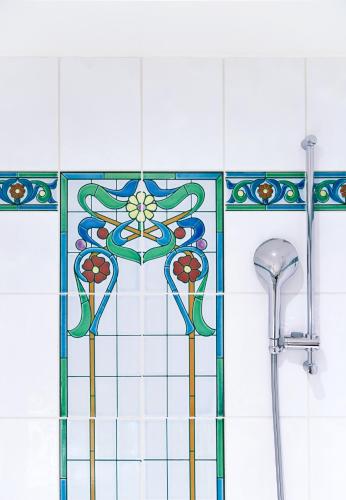 a bathroom with a stained glass window and a shower at Hôtel Tiffany by Fassbind in Geneva