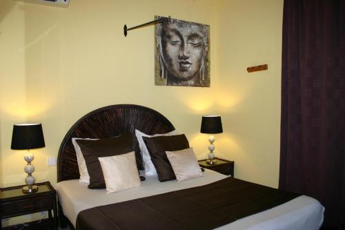 a bedroom with a bed with a picture of a woman at Résidence Syrina 1 in Trou aux Biches