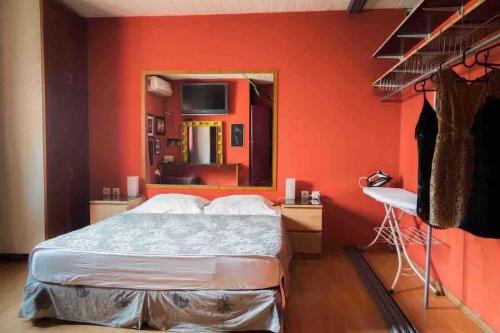 um quarto com uma parede laranja com uma cama e um espelho em Argostoli`s Heard em Argostoli