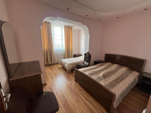 ein Schlafzimmer mit 2 Betten und einem Stuhl darin in der Unterkunft Apartment in Yerevan in Yerevan