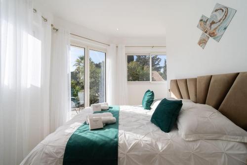 - une chambre dotée d'un grand lit avec des oreillers verts et blancs dans l'établissement Superbe Nouvelle Villa Moderne, à Cannes