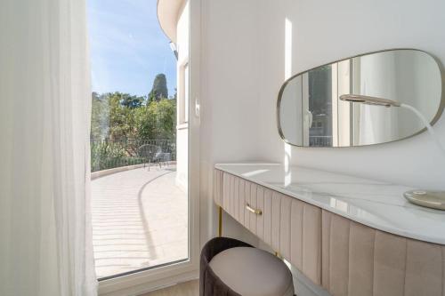 La salle de bains est pourvue d'un miroir sur un comptoir et d'une fenêtre. dans l'établissement Superbe Nouvelle Villa Moderne, à Cannes
