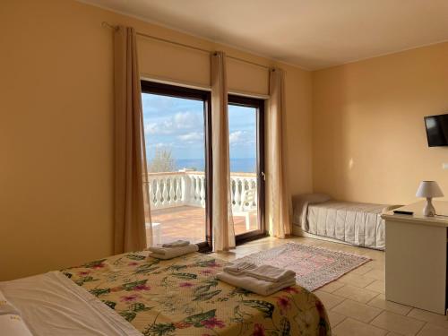 a bedroom with a bed and a large window at Residenza Domus Aurea Tropea- Vista Mare in Tropea