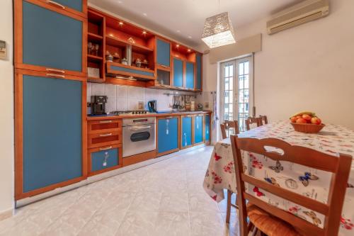 a kitchen with blue cabinets and a table with chairs at Luisa Flat - Metro Basilica San Paolo in Rome