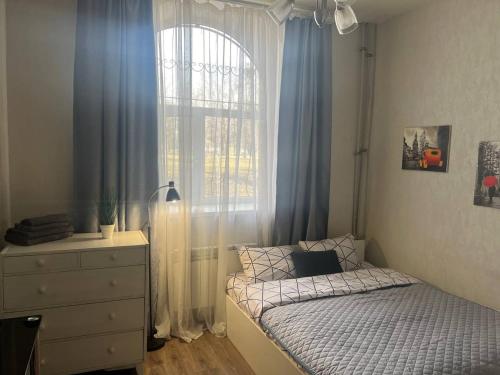ein kleines Schlafzimmer mit einem Bett und einem Fenster in der Unterkunft Smart in Kharkov