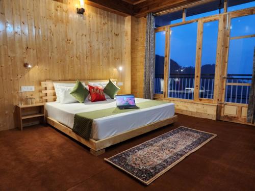 a bedroom with a bed with a laptop on it at Gadegal Homestay Narkanda - Rooms & Pahadi Café in Shimla