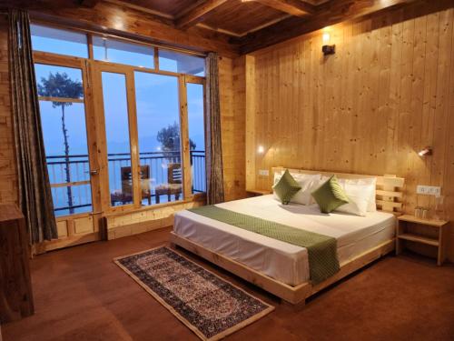 a bedroom with a bed and a large window at Gadegal Homestay Narkanda - Rooms & Pahadi Café in Shimla