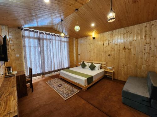 a bedroom with a bed and a couch in a room at Gadegal Homestay Narkanda - Rooms & Pahadi Café in Shimla
