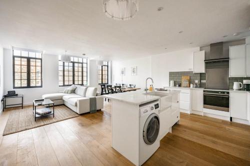 a kitchen and living room with a washing machine at Host & Stay - The Old Post Office in Norwich