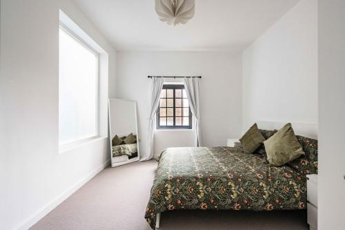 1 dormitorio con cama y ventana en The Old Post Office - Norfolk Holiday Properties, en Norwich