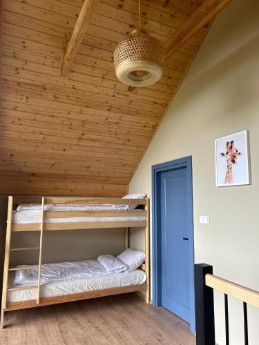a room with bunk beds in a wooden ceiling at POLUBKOVO domki wypoczynkowe sauna balia basen jezioro in Lubkowo