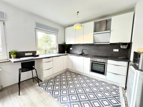 uma cozinha com armários brancos e um tapete preto e branco em Comfy Apartment mit Garten in Köln em Colônia
