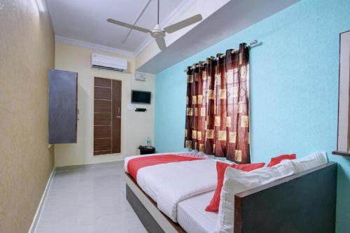 1 dormitorio con 1 cama y ventilador de techo en Hotel Silver, en Surat