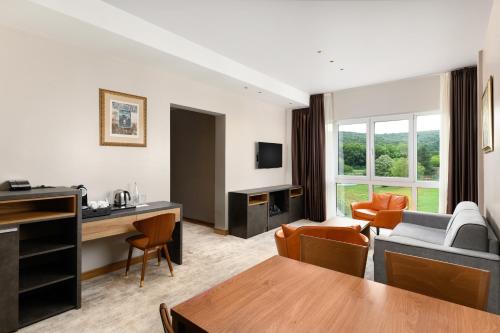 a living room with a couch and a table at Movenpick Resort and Spa Fruske Terme in Vrdnik