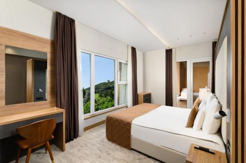 a bedroom with a bed and a large window at Movenpick Resort and Spa Fruske Terme in Vrdnik