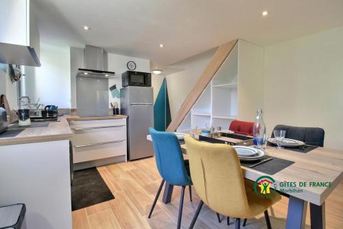 une cuisine et une salle à manger avec une table et des chaises dans l'établissement La Fleur de Vie, à Pluneret