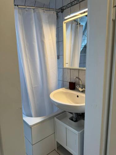 a bathroom with a sink and a mirror at Gemütliche Dachgeschosswohnung mit Stellplatz - R9-DGr in Lohfelden