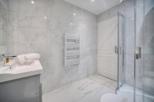 une salle de bain blanche avec une douche et un lavabo dans l'établissement Charmant 3 pieces centre ville A2B243, à Cannes