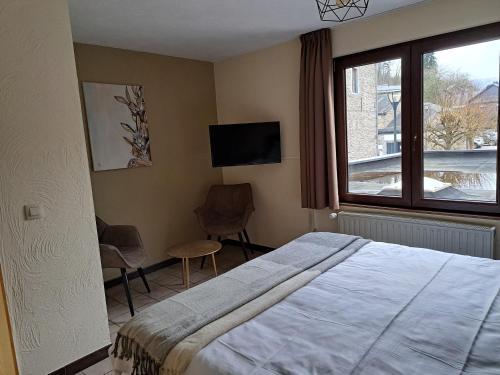 a bedroom with a bed and a window and a tv at Au Coeur d'Alle in Alle