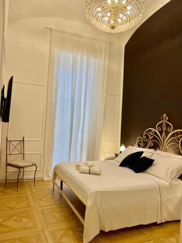a bedroom with a large bed with a chandelier at Fiorentine Relais in Naples