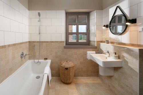 ein Badezimmer mit einer Badewanne, einem Waschbecken und einem Spiegel in der Unterkunft Rustic Villa Calluna with a pool in Istria in Sveti Lovreč Pazenatički