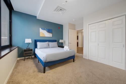 a bedroom with a bed and a blue wall at 1B1B Upscale Charm Valet Gym Lounge Roku in Pittsburgh