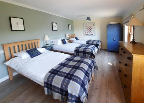 a bedroom with two beds and a blue cabinet at Castle Reach Newport, Pembrokeshire in Newport Pembrokeshire