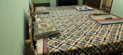 a bed with a quilt and pillows on it at Vikistays in Chennai