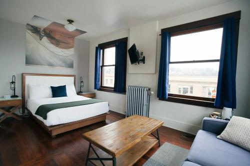 a bedroom with a bed and a table and a couch at Commodore Hotel in Astoria, Oregon