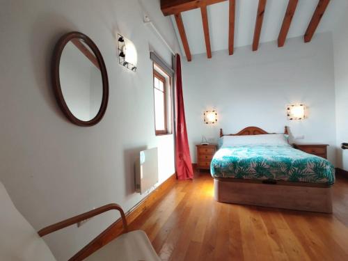 une chambre avec un lit et un miroir au mur dans l'établissement Apartamentos Copi Villa de Suances, à Suances