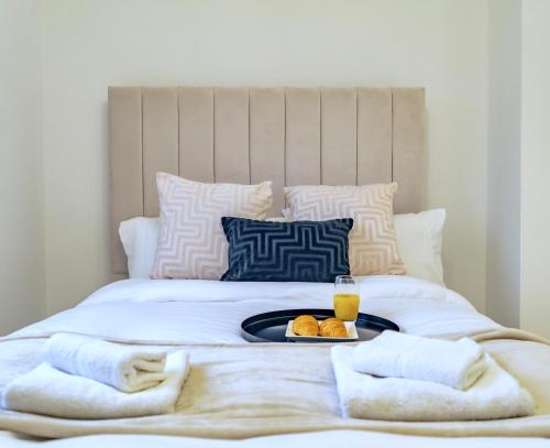 a bed with a tray of food and a drink on it at Modern 2 Bedroom Home in Edinburgh Free Parking in Edinburgh
