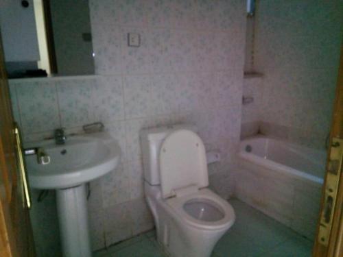uma casa de banho com um WC branco e um lavatório. em Cozy Homestay Private Room: Home-Away-Home em Addis Ababa