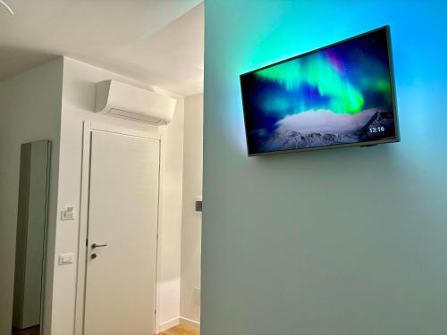 una TV a schermo piatto appesa a un muro in una camera di B&B 969 a Paceco