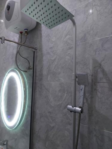 a shower with a mirror and a light in a bathroom at Soulmate Hotels & Suites in Lagos
