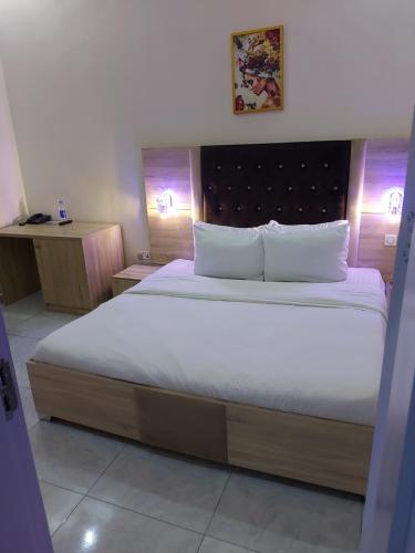 a bedroom with a large bed with white sheets and pillows at Soulmate Hotels & Suites in Lagos