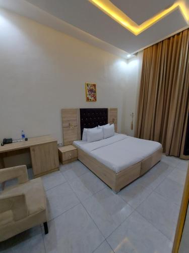 a bedroom with a large bed and a chair at Soulmate Hotels & Suites in Lagos