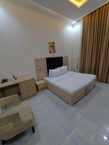 a bedroom with a bed and a desk and a chair at Soulmate Hotels & Suites in Lagos