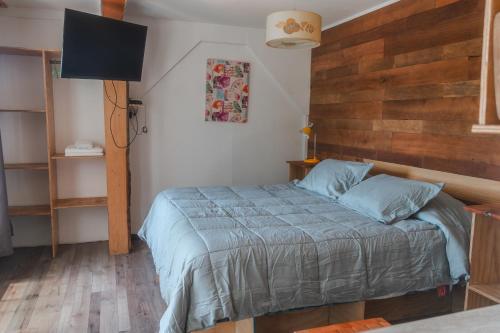 a bedroom with a bed with a wooden wall at Cabañas El Bosque in Maitencillo