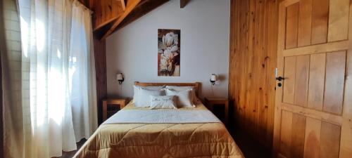 um quarto com uma cama e uma porta de madeira em Cabaña Centrica Maiten II em San Martín de los Andes